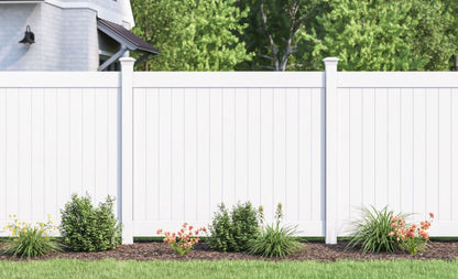 White vinyl fence with a house and trees in the background